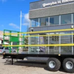 Grön balvagn 12 ton uppställd utomhus på grusplan